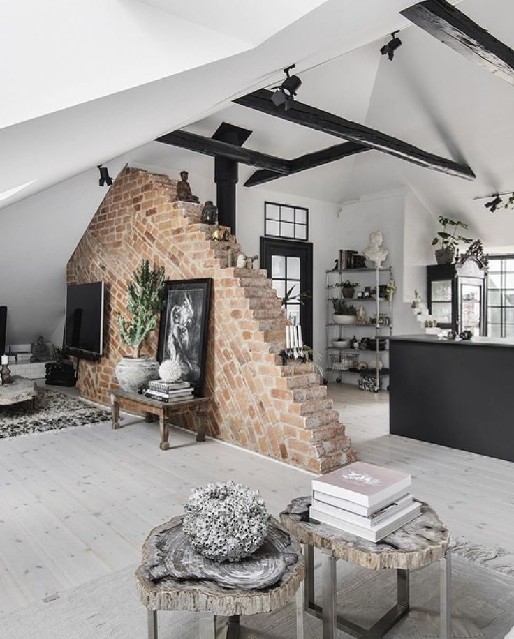 Stylish loft interior with exposed brick wall, modern decor, and black accents, featuring unique natural wood tables.