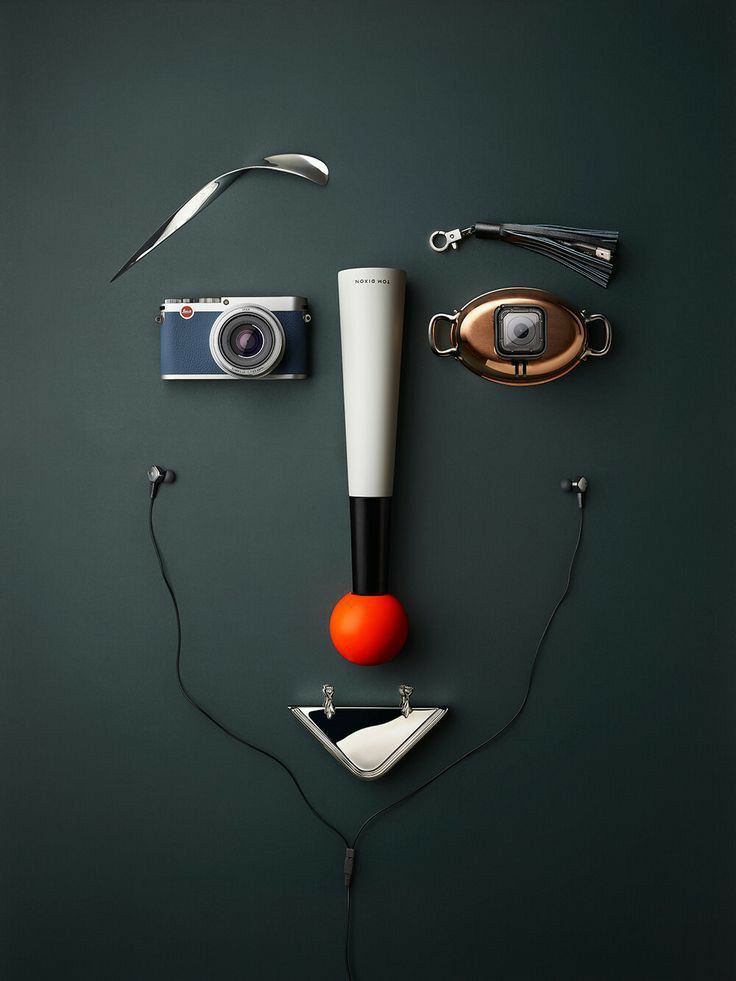 Creative face made of gadgets and items against a dark background, featuring a camera and earphones.