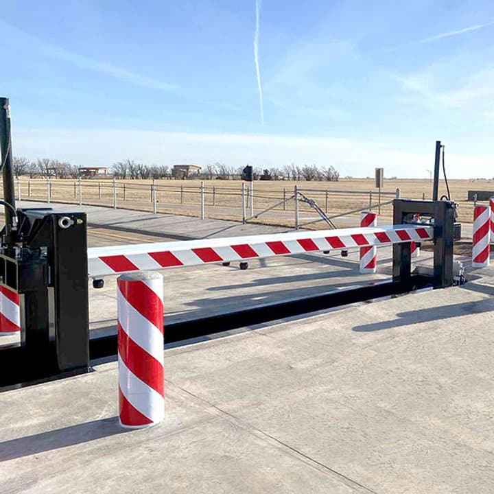 5b40e1_bd44e05412fe421786cc3e355d8cb888~mv2 Red and white security barrier gate on a sunny day, guarding an entrance with open land in the background. | Sky Rye Design Red and white security barrier gate on a sunny day, guarding an entrance with open land in the background.