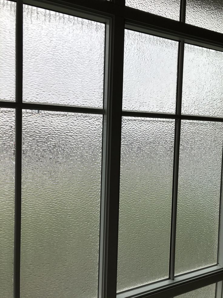 Frosted glass window panes allowing diffused light, ideal for privacy and modern interior design.