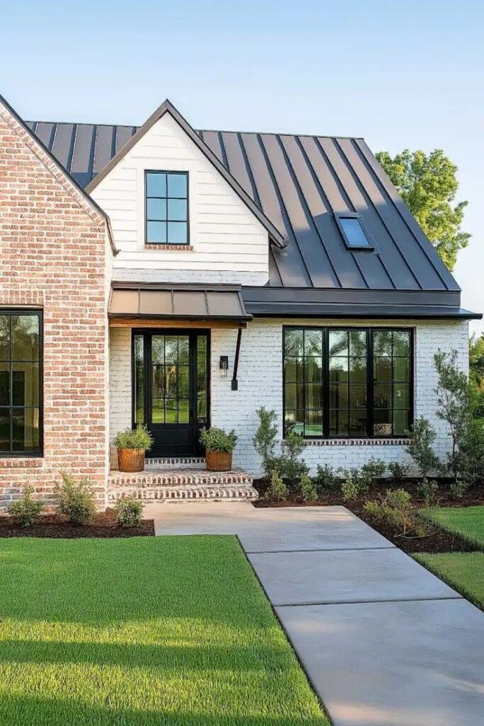 Modern brick house with large windows, metal roof, and lush landscaped lawn under a clear blue sky.