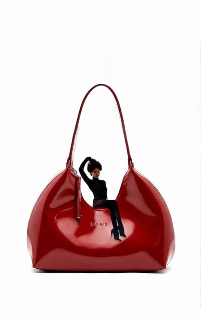 _ 6 Stylish red handbag with a doll figure in sleek black attire, creative fashion concept on white background. | Sky Rye Design Stylish red handbag with a doll figure in sleek black attire, creative fashion concept on white background.