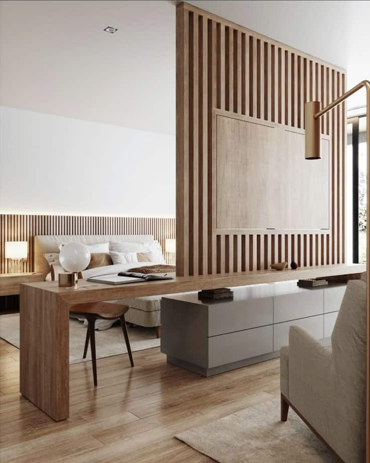 Modern bedroom with wood accents, sleek desk, beige armchair, and natural light for a cozy, contemporary feel.