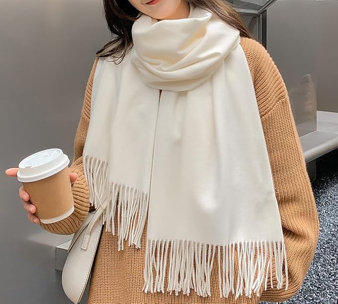 61QlyFmv3iL_AC_SX679_ Woman wearing white fringed scarf and brown sweater, holding a coffee cup, on a city street. | Sky Rye Design Woman wearing white fringed scarf and brown sweater, holding a coffee cup, on a city street.