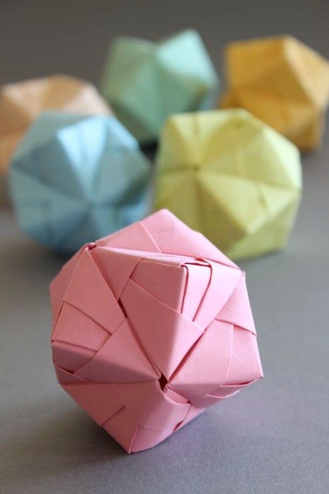 6694c83be8d8b6baafcbf30e32ab9001 Colorful origami polyhedra on a gray background, featuring pink, blue, and yellow paper art. | Sky Rye Design Colorful origami polyhedra on a gray background, featuring pink, blue, and yellow paper art.