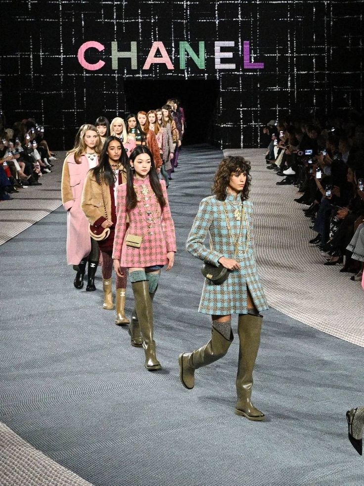 679dce72-0992-4ded-b8f9-172ad0275ea5 Models walk down Chanel runway in colorful plaid outfits, high boots, and accessories. Fashion show audience in background. | Sky Rye Design Models walk down Chanel runway in colorful plaid outfits, high boots, and accessories. Fashion show audience in background.