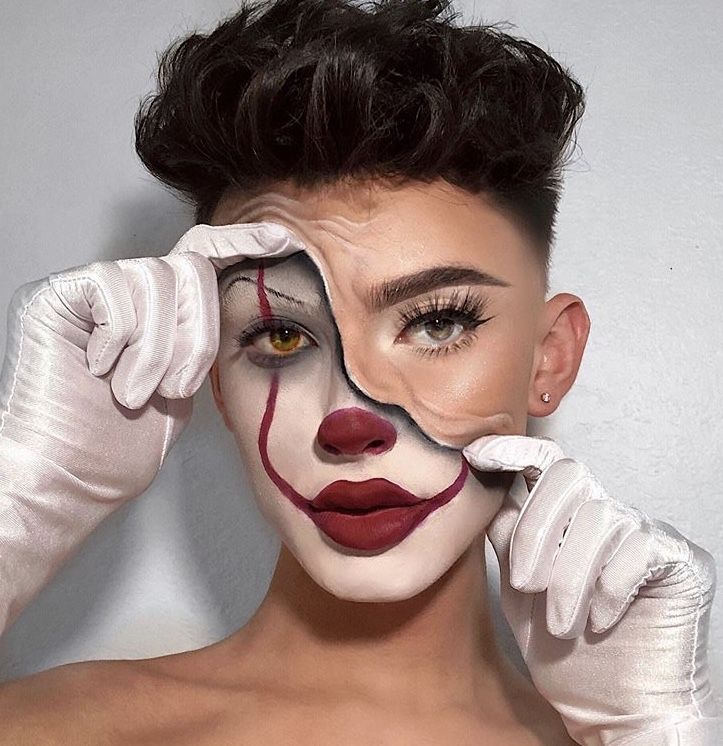 Person in clown makeup peels mask, revealing half natural face, wearing white gloves. Creative makeup transformation.