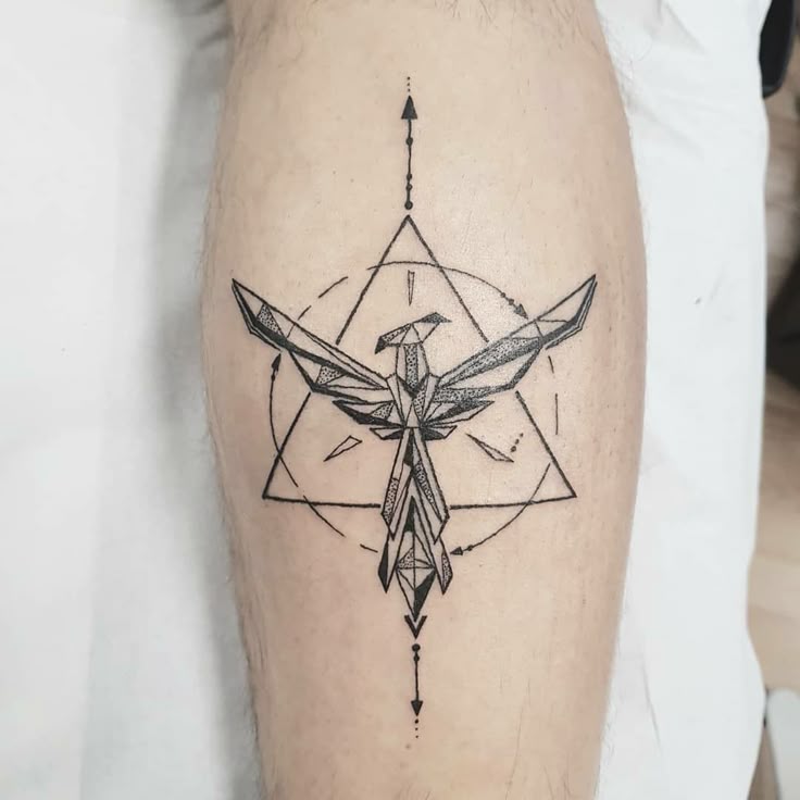 Geometric bird tattoo with triangular design and arrows on a person's calf.