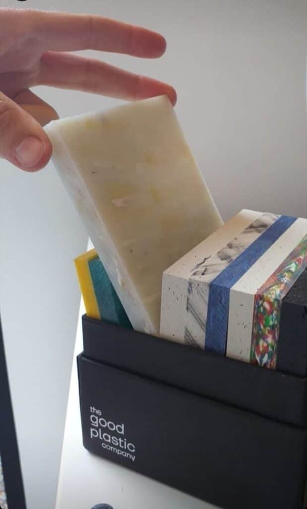 Hand selecting recycled plastic samples from The Good Plastic Company collection for sustainable design.