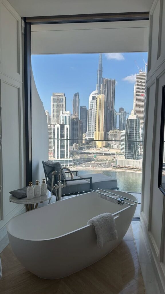 724a34e1-004d-482e-876d-0f418fa8f436 Luxurious bathroom with a freestanding tub and stunning cityscape view through floor-to-ceiling windows. | Sky Rye Design Luxurious bathroom with a freestanding tub and stunning cityscape view through floor-to-ceiling windows.