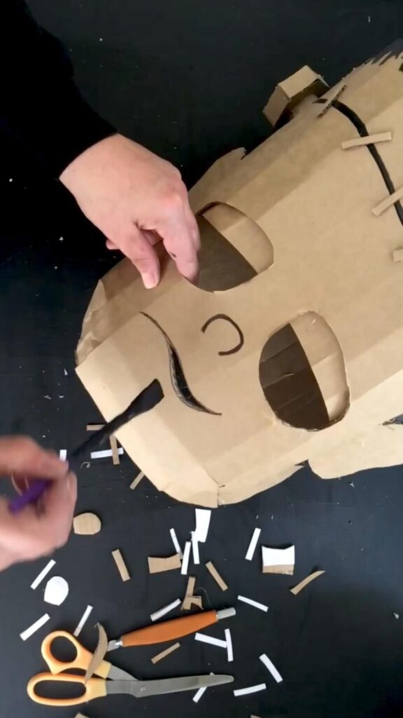 7a31dfb41a790fae10c953279f3cd065 Creating a cardboard mask with scissors and a craft knife on a black table. | Sky Rye Design Creating a cardboard mask with scissors and a craft knife on a black table.