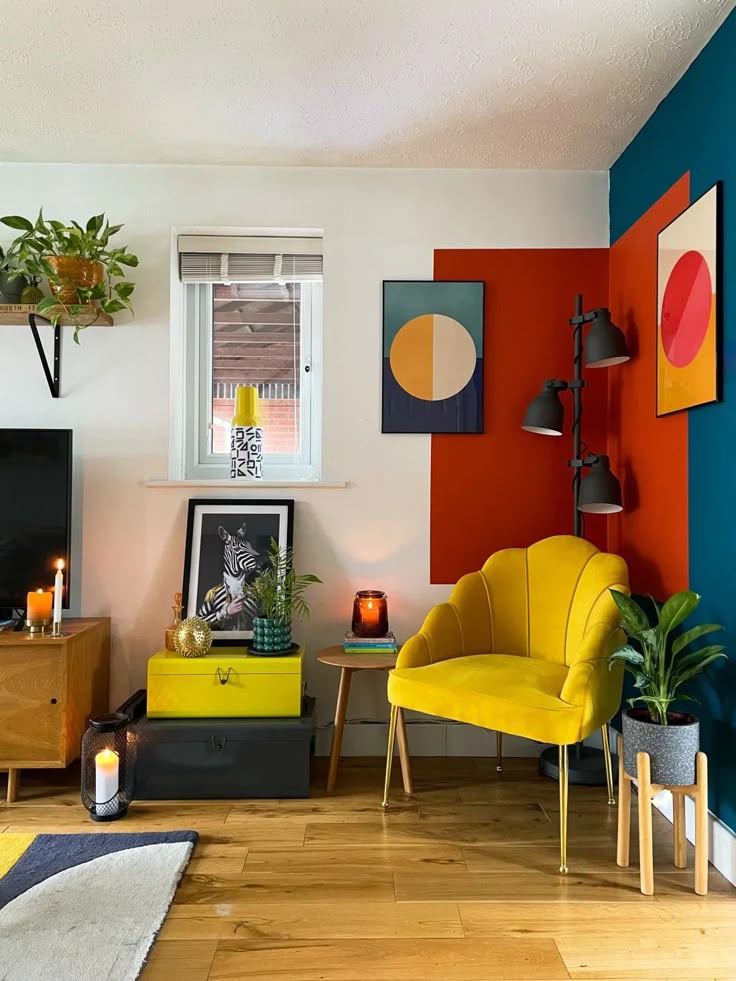 Colorful modern living room with yellow chair, abstract art, and plants. Cozy decor includes candles and wooden accents.