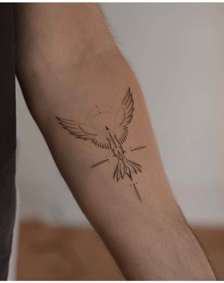 Minimalist phoenix tattoo on forearm with wings spread, symbolizing rebirth and renewal.