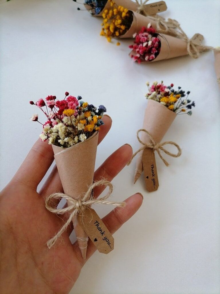Miniature bouquet with colorful dried flowers, wrapped in kraft paper with a Thank you tag, held in hand.