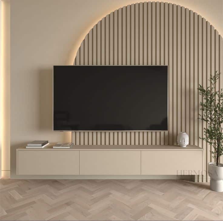 Modern living room with wall-mounted TV, beige cabinet, and decorative plant, featuring minimalist design elements.