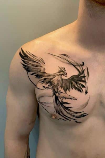 Black phoenix tattoo design on a man's chest, showcasing detailed wings and dynamic movement for a bold artistic statement.