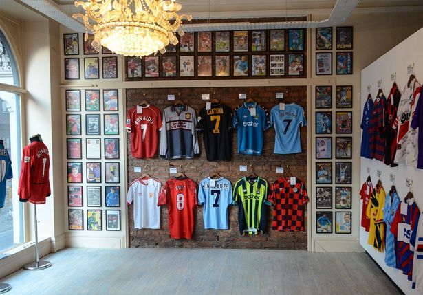 Vintage soccer jerseys displayed in a stylish room with framed memorabilia and a decorative chandelier.
