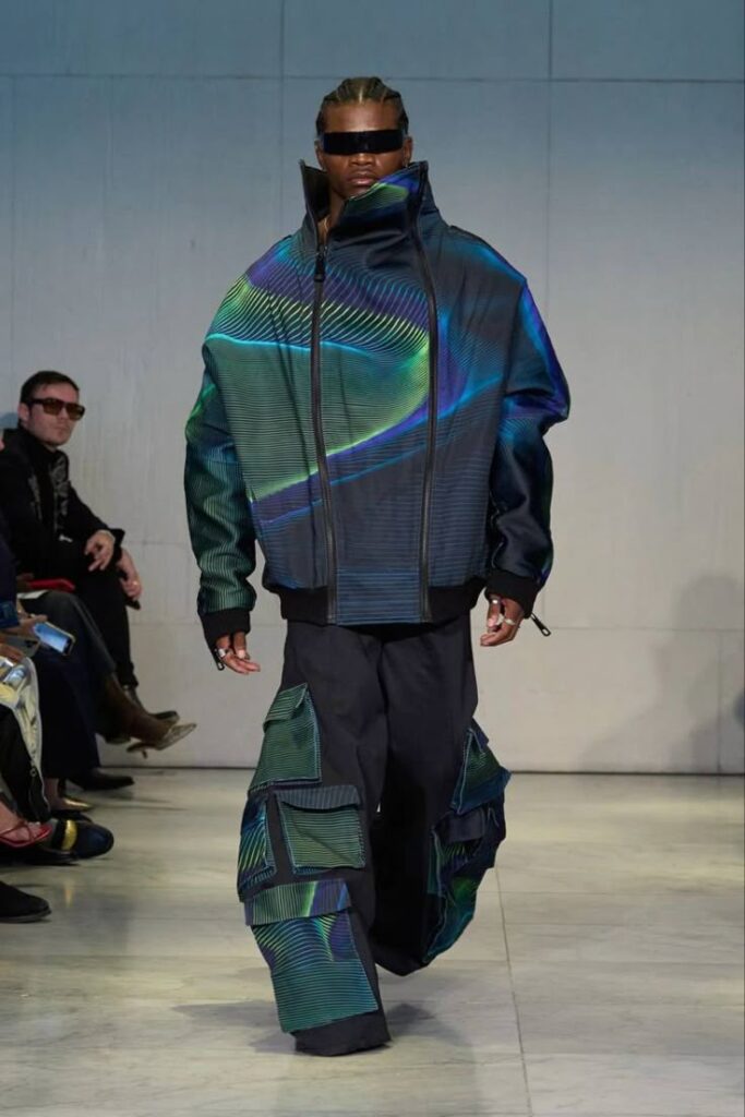 _ 9 Model in futuristic outfit with geometric patterns walks down the runway at a fashion show. | Sky Rye Design Model in futuristic outfit with geometric patterns walks down the runway at a fashion show.