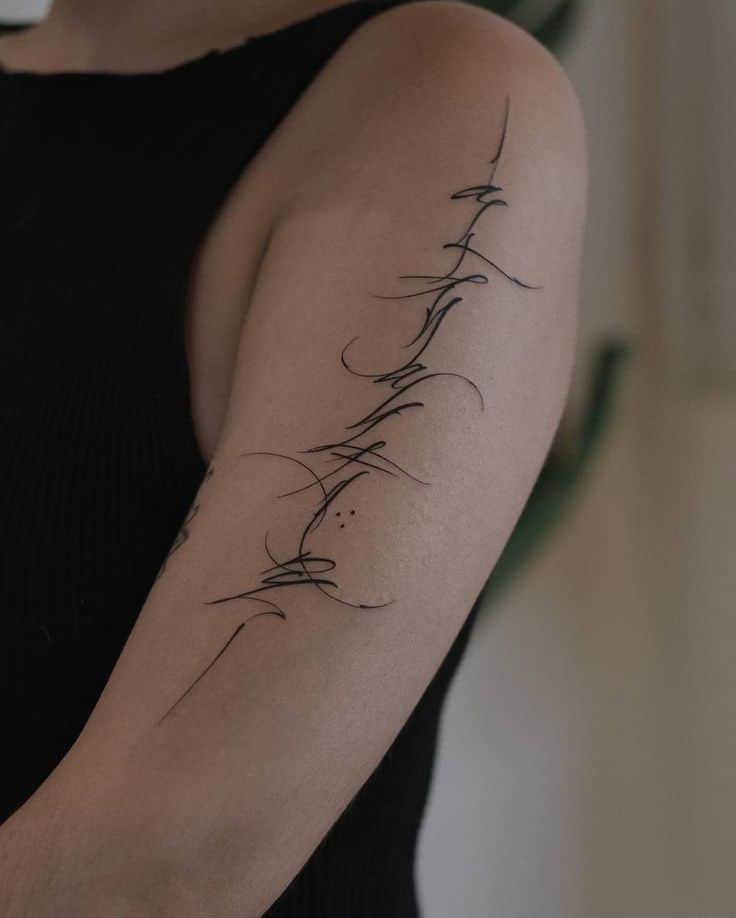 Abstract linework tattoo on arm in black ink, showcasing delicate, intricate design against a dark sleeveless top.