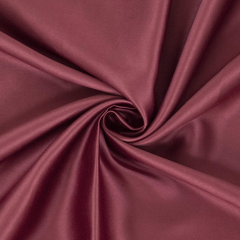 Deep red satin fabric with elegant folds showcasing its smooth texture and rich color. Ideal for fashion and upholstery uses.
