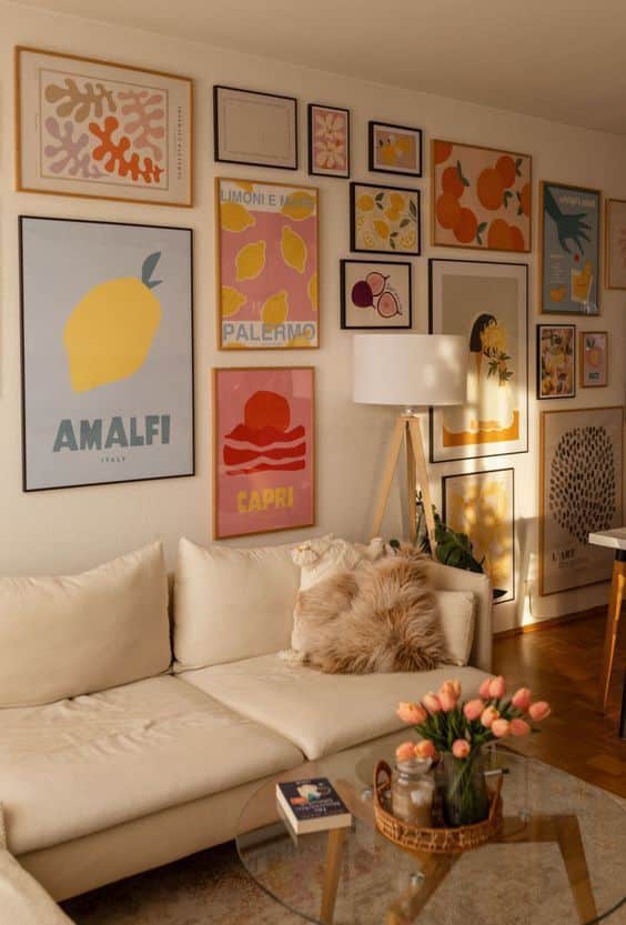 Cozy living room with vibrant travel posters, soft beige sofa, and tulips on a glass coffee table.