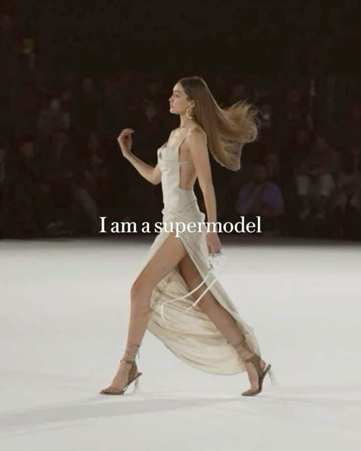 Model strutting on runway in elegant white dress with high slit, I am a supermodel text overlay.