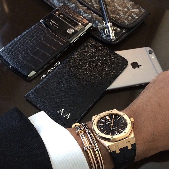 Luxury accessories: modern smartphone, leather wallet, and wristwatch on display.
