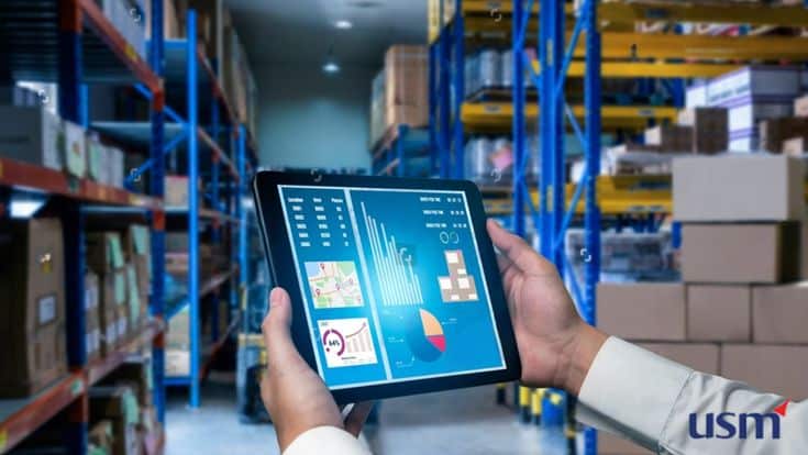 AI in Inventory Management Development Person using a tablet for inventory management in a warehouse with shelves full of boxes. | Sky Rye Design Person using a tablet for inventory management in a warehouse with shelves full of boxes.