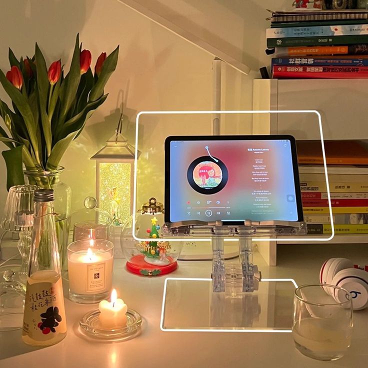 Cozy desk setup with tablet stand, candles, and books, creating a warm and inviting ambiance for relaxation.