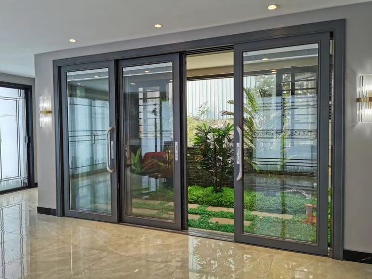 Modern sliding glass doors opening to a lush garden view, brightening the interior space.