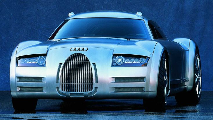 Sleek, futuristic silver car with distinctive grille and round headlights against a blue background.
