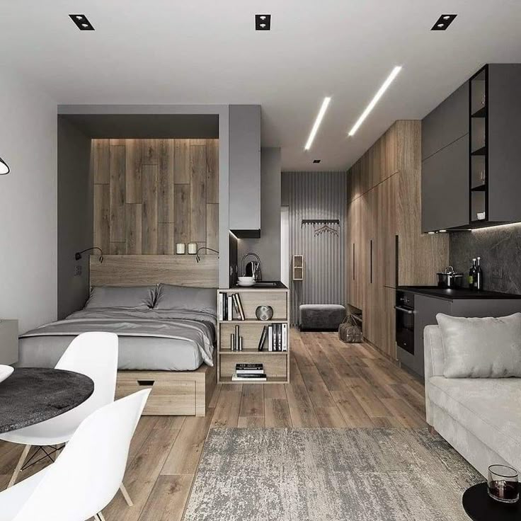 Stylish modern studio apartment with wood accents, featuring a cozy bed, kitchen, and dining area under sleek lighting.