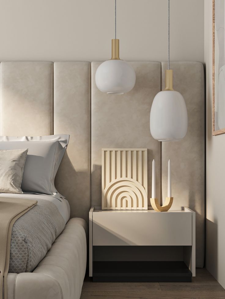 Modern bedroom with elegant pendant lights, neutral decor, and sleek bedside table featuring artistic accents.