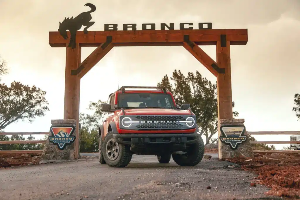 Bronco-Off-Roadeo_01-scaled Red Ford Bronco parked under a rustic wood sign, perfect for off-road adventures. | Sky Rye Design Red Ford Bronco parked under a rustic wood sign, perfect for off-road adventures.
