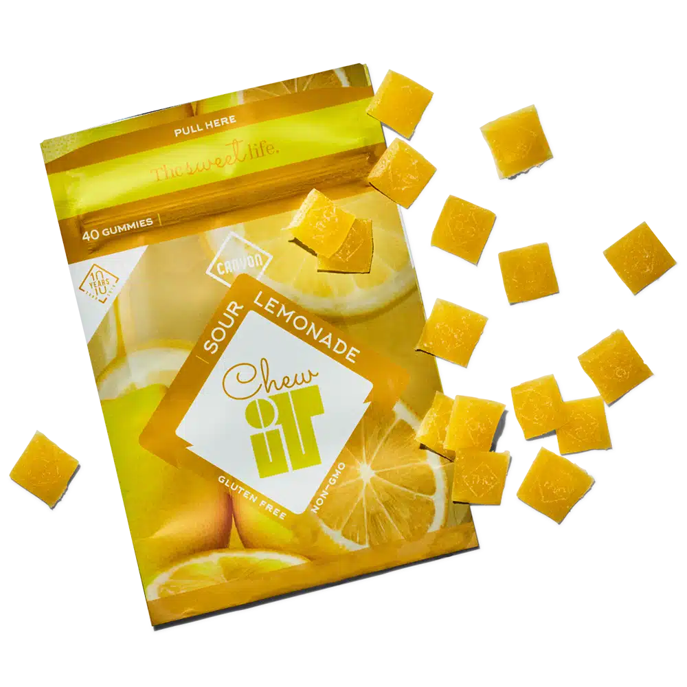 Canyon_ChewIt_Sour_Lemonade-NOCANNA Sour lemonade gummies spilling from package, gluten-free and non-GMO treats with vibrant yellow color. | Sky Rye Design Sour lemonade gummies spilling from package, gluten-free and non-GMO treats with vibrant yellow color.