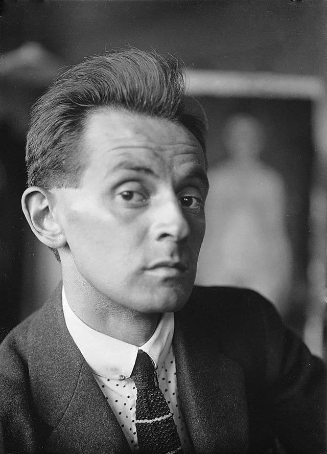Vintage black and white portrait of a man in a suit with a serious expression.
