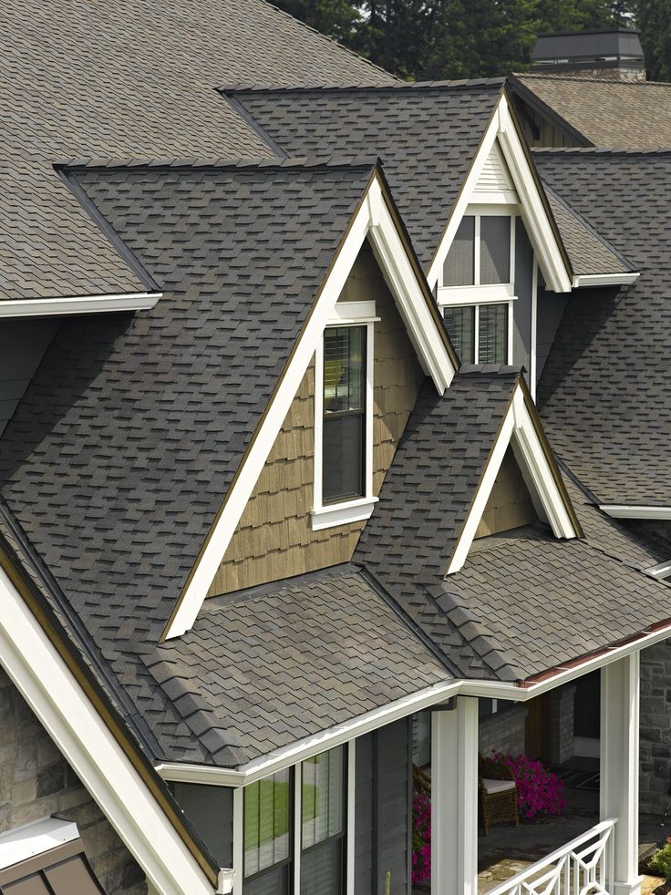 Contemporary house with dark asphalt shingle roof and gable design, showcasing modern architecture and durability.