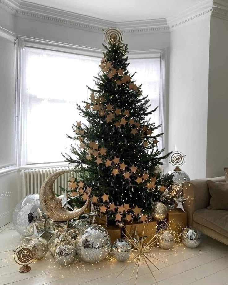Stylish Christmas tree with star decorations and disco balls in a cozy living room corner.