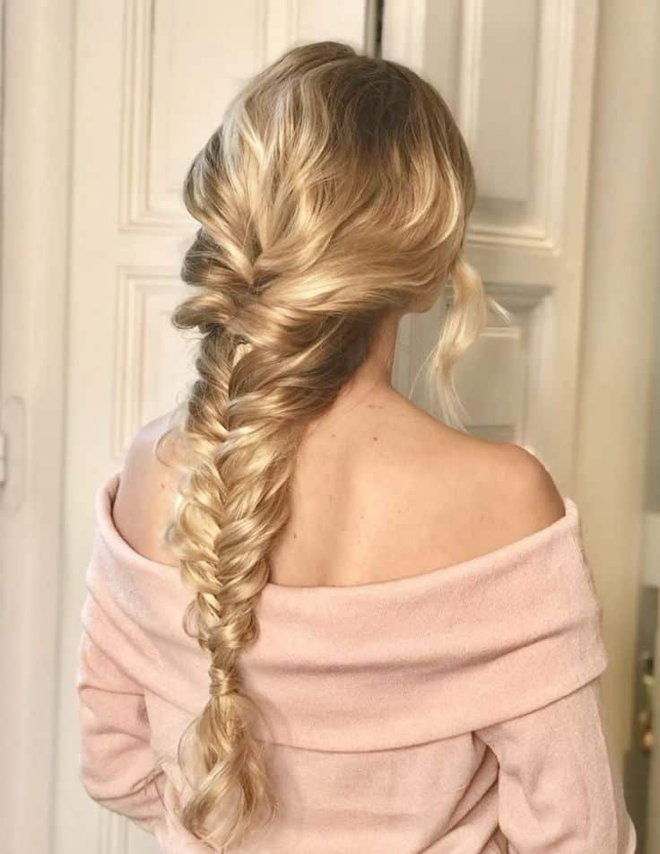 Elegant braided hairstyle on blonde woman wearing an off-shoulder pink sweater, back view.