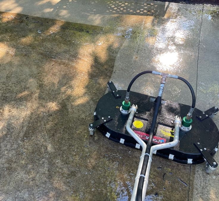 Concrete surface being cleaned with a professional pressure washer, displaying clear before and after results.