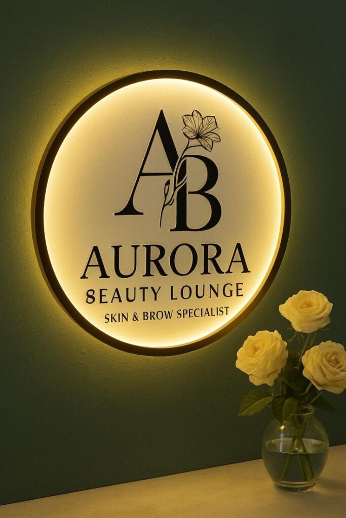 Custom Acrylic Business Signage _ Round Acrylic Signs for Business _ Custom Office Wall Sign Wall Decor for office Illuminated salon sign reading Aurora Beauty Lounge with yellow roses in a vase nearby. | Sky Rye Design Illuminated salon sign reading Aurora Beauty Lounge with yellow roses in a vase nearby.