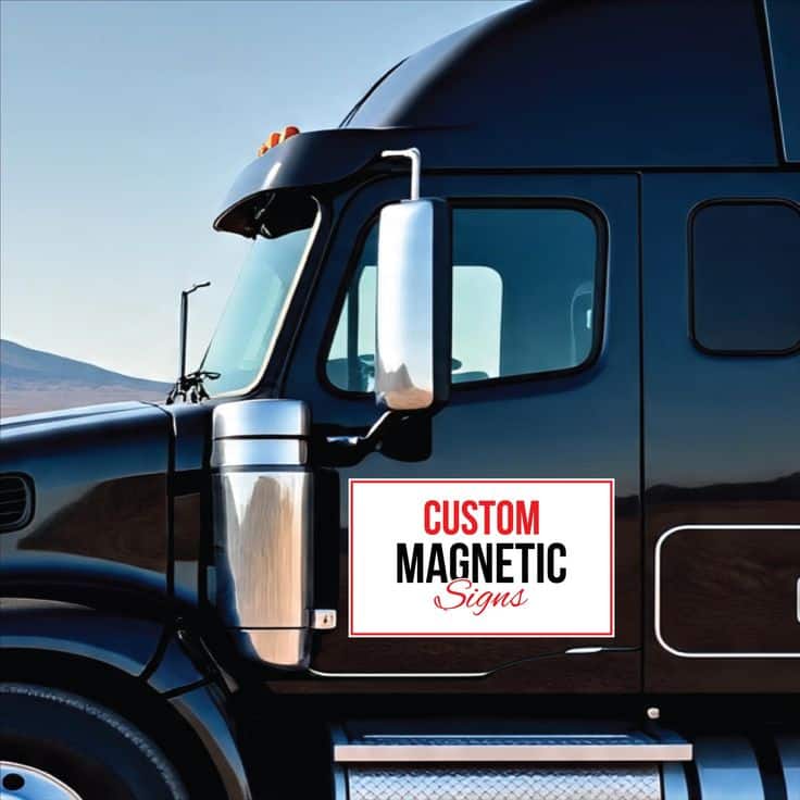 Black truck featuring a custom magnetic sign on the door, showcased outdoors against a clear sky background.