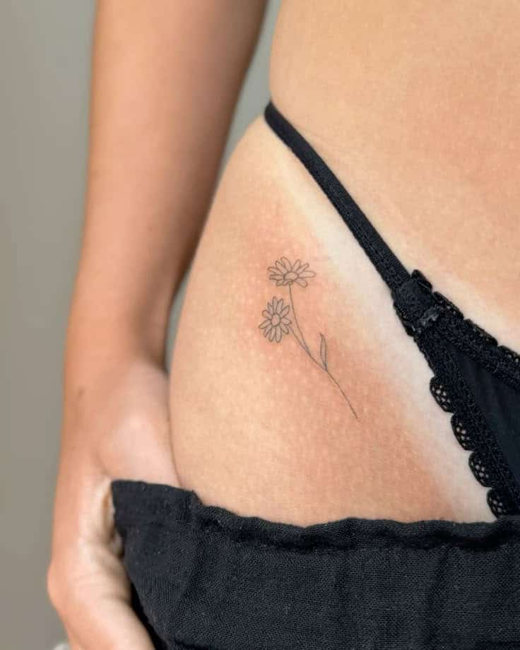 Minimalist floral tattoo on hip with black lace lingerie.