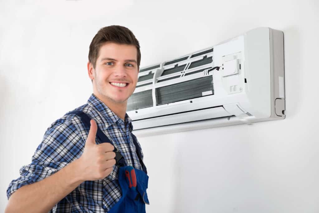 Depositphotos_104089366_XL Technician giving thumbs up while inspecting air conditioner unit on wall. | Sky Rye Design Technician giving thumbs up while inspecting air conditioner unit on wall.