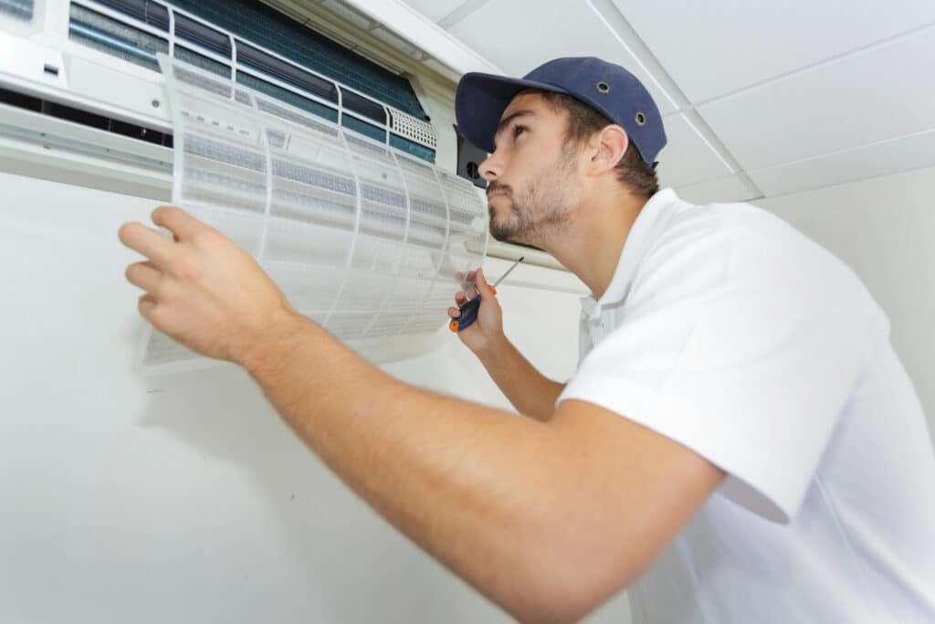 Depositphotos_139097826_XL Technician inspecting and cleaning an air conditioning unit filter, optimizing HVAC system performance. | Sky Rye Design Technician inspecting and cleaning an air conditioning unit filter, optimizing HVAC system performance.