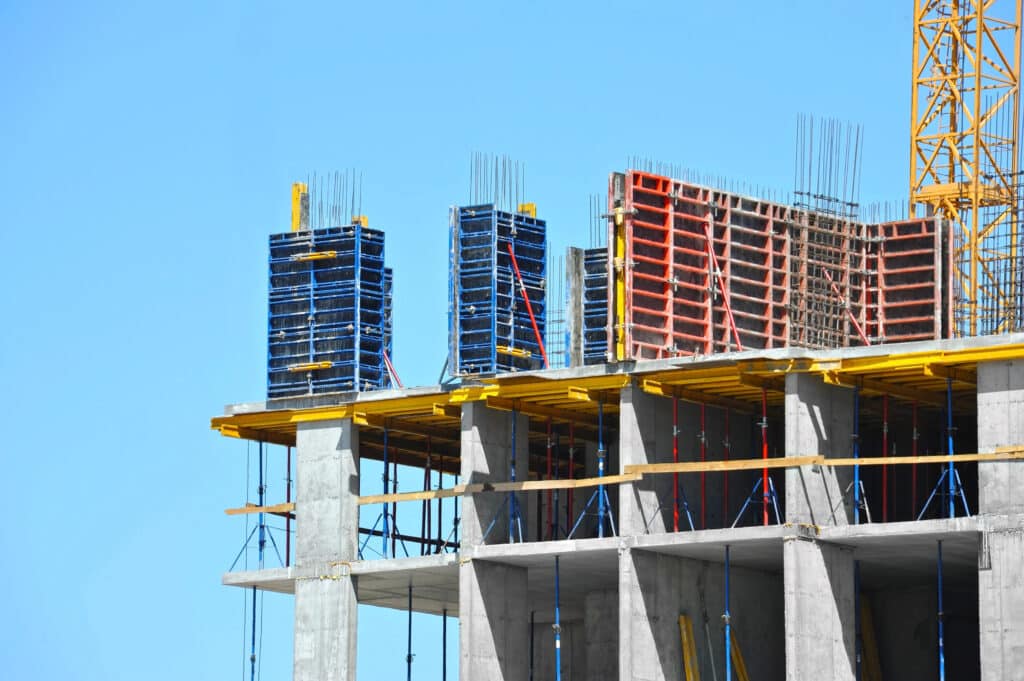 Depositphotos_199485718_XL Building under construction with formwork and scaffolding against a clear blue sky. | Sky Rye Design Building under construction with formwork and scaffolding against a clear blue sky.