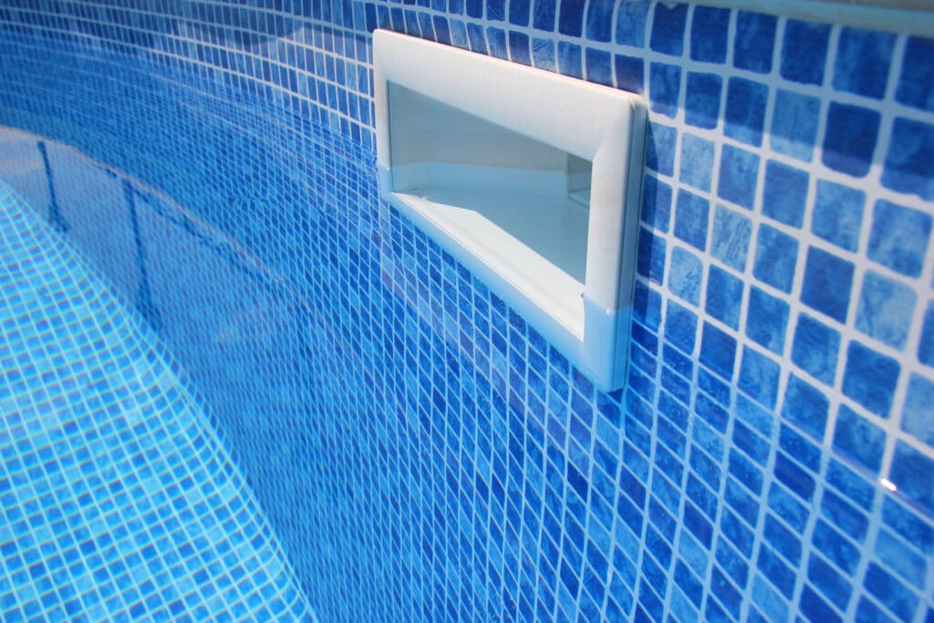 Blue tile pool wall with a skimmer in a close-up view.