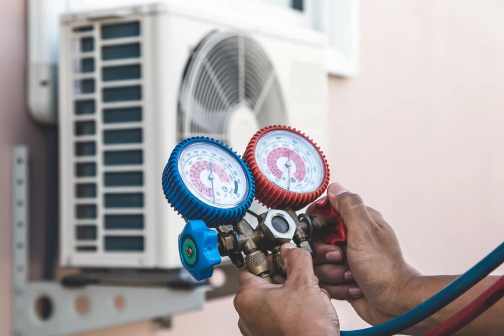 Depositphotos_393207006_XL Technician checking air conditioner pressure with HVAC gauges for maintenance. | Sky Rye Design Technician checking air conditioner pressure with HVAC gauges for maintenance.