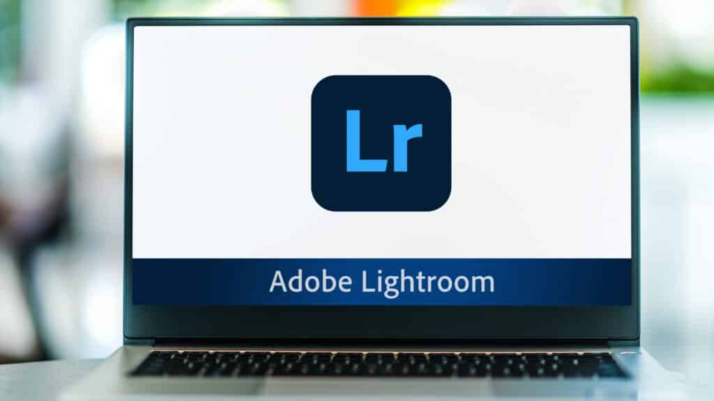 Laptop displaying Adobe Lightroom logo on screen.