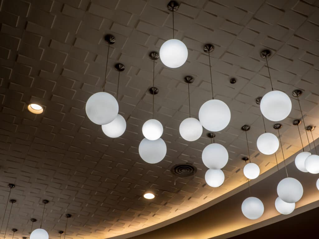 Modern ceiling with spherical pendant lights casting a soft glow in a spacious room.